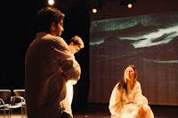 a group of people sitting on a stage in front of a projection